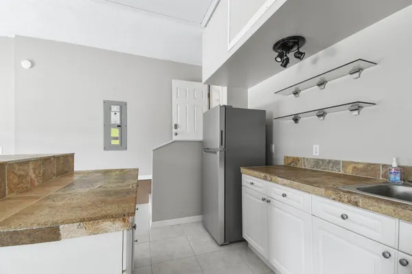 a kitchen with granite countertop a refrigerator and a sink