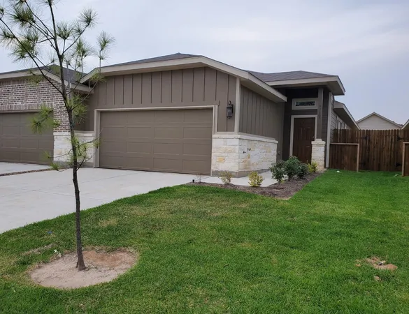 a front view of house with yard and garage