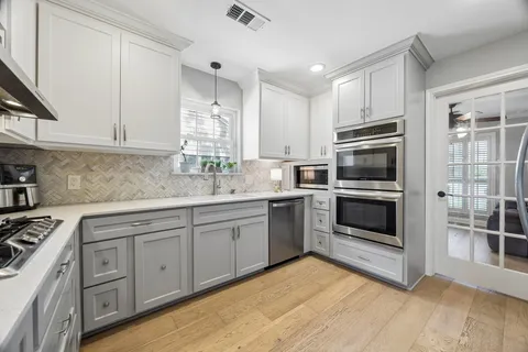 a kitchen with cabinets stainless steel appliances and sink