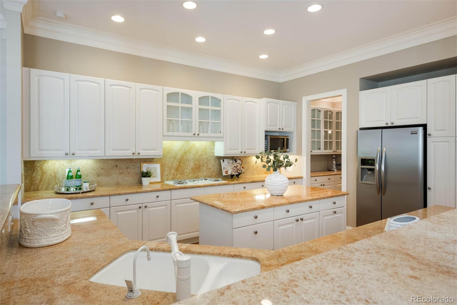 470 Monroe Street Denver, CO 80206 - Photo 8 of 40 a kitchen with stainless steel appliances granite countertop a sink refrigerator and cabinets