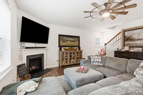 a living room with furniture a flat screen tv and a fireplace
