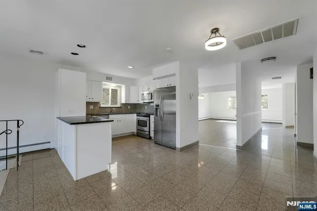 a kitchen with refrigerator and cabinets