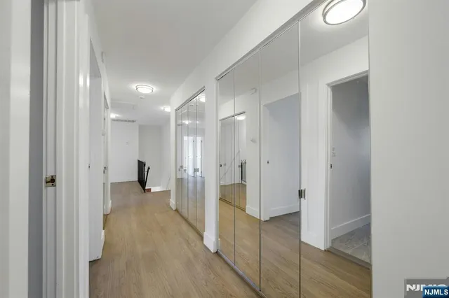 a view of a hallway with wooden floor