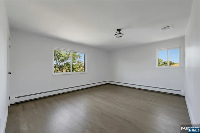 an empty room with wooden floor and window