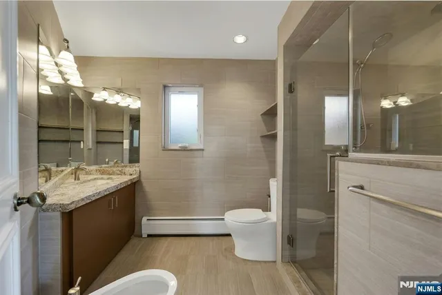 a bathroom with a sink a toilet and shower