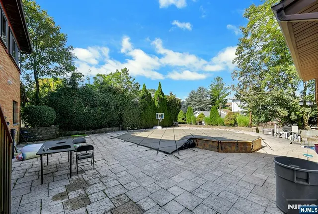 a roof deck with table and chairs and potted plants