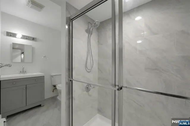 a bathroom with a shower sink vanity and mirror