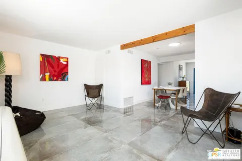 a living room with furniture and a view of kitchen
