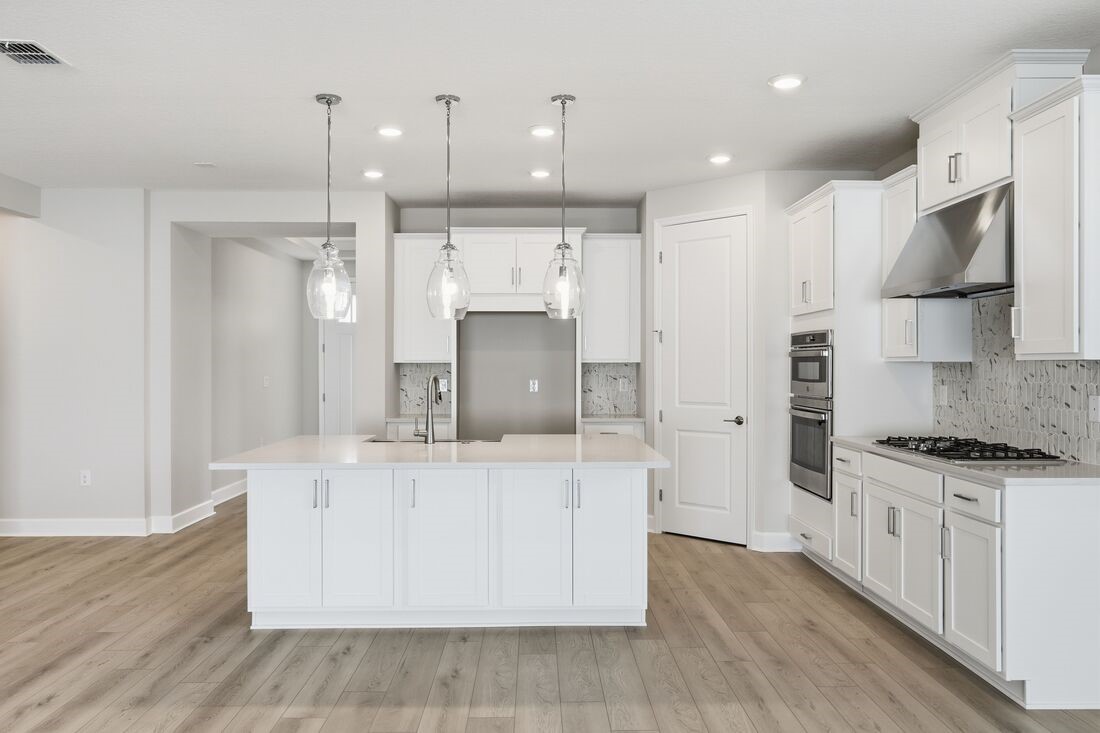 86654 Swift Launch Path Yulee, FL 32097 - Photo 2 of 31 a kitchen with stainless steel appliances granite countertop a stove a sink a refrigerator and a oven with wooden floor