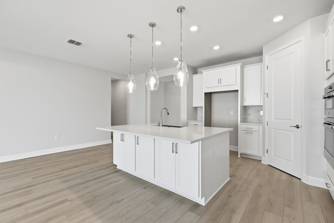 86654 Swift Launch Path Yulee, FL 32097 - Photo 4 of 31 a large white kitchen with a large island oven a sink stainless steel appliances and cabinets