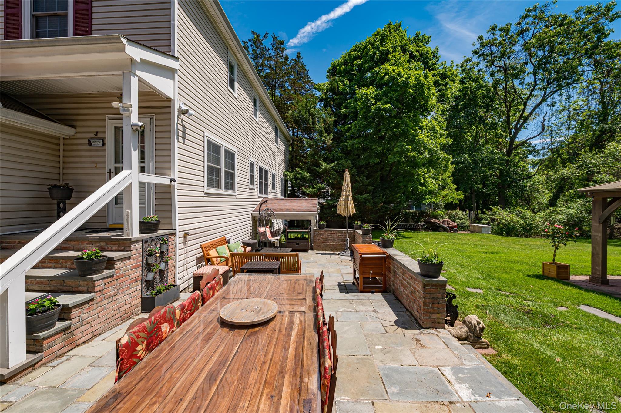 3 Thompson Hill Road St. James, NY 11780 - Photo 30 of 34 a view of a patio with couches table and chairs with plants and wooden fence