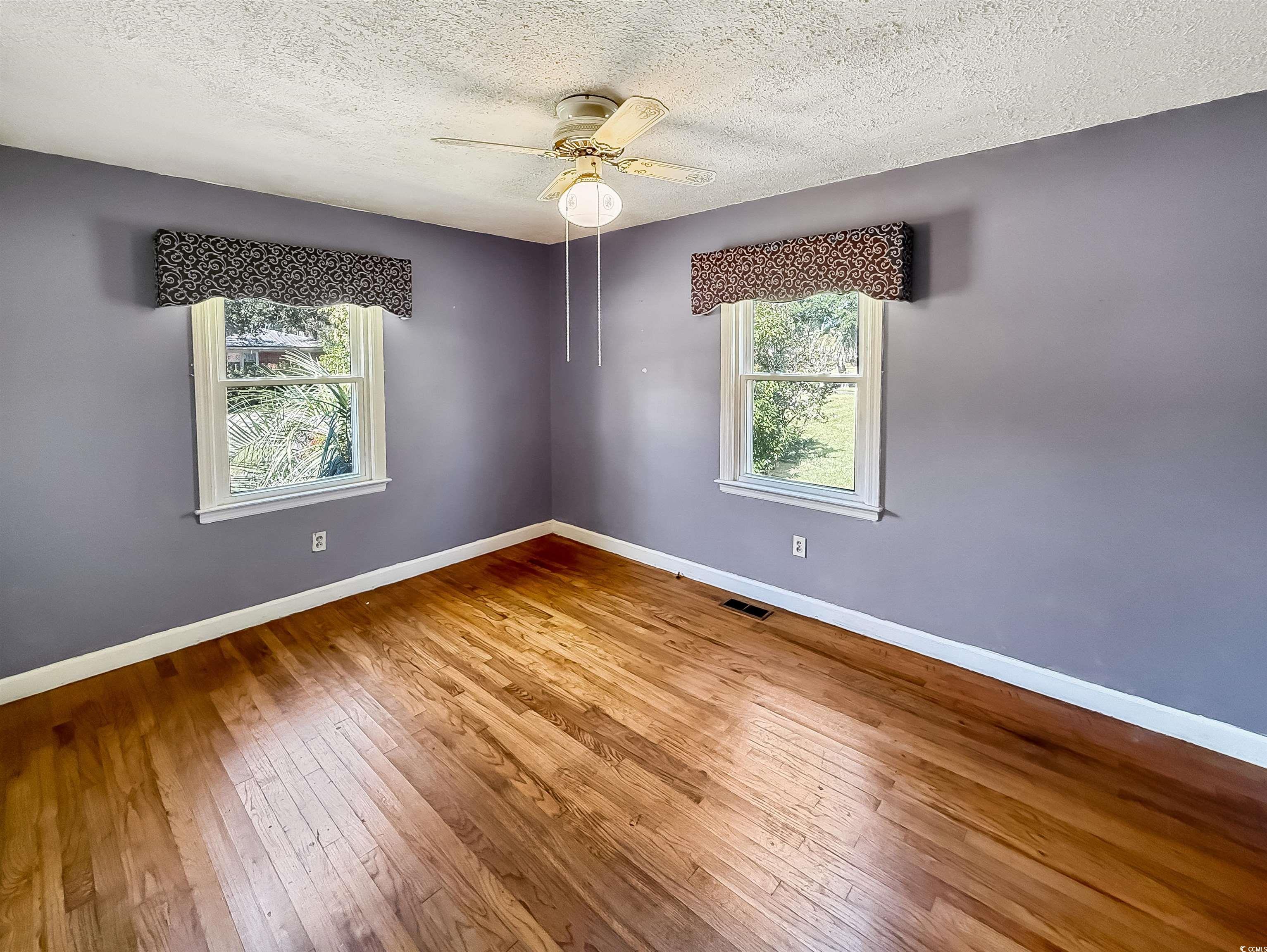 1682 Pickens Street Georgetown, SC 29440 - Photo 25 of 39 Empty room featuring a textured ceiling, light wood finished floors, and ceiling fan