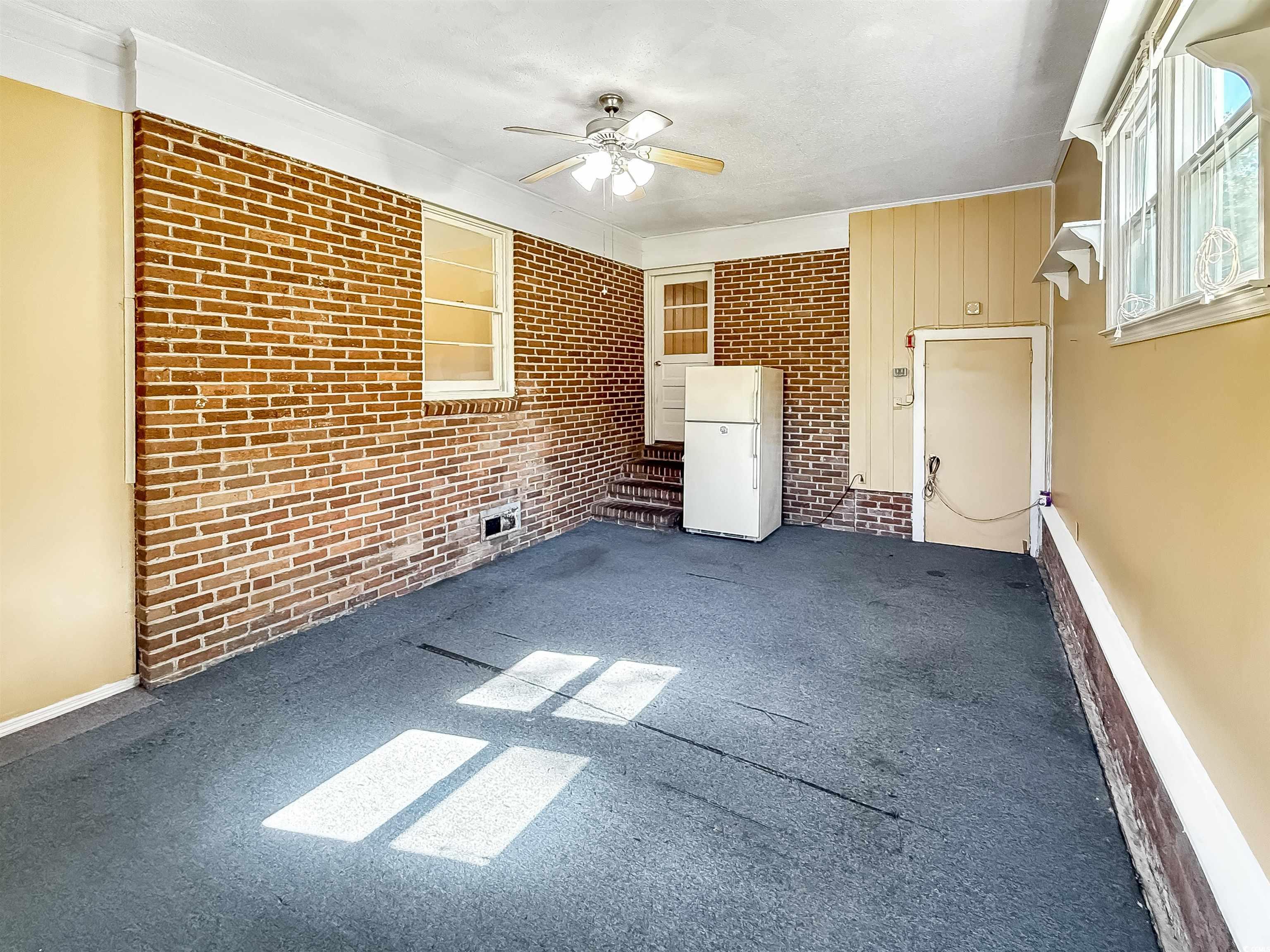 1682 Pickens Street Georgetown, SC 29440 - Photo 33 of 39 Unfurnished living room featuring carpet flooring, brick wall, and ceiling fan
