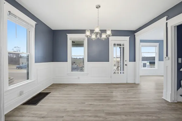 a view of a livingroom with wooden floor and a chandelier