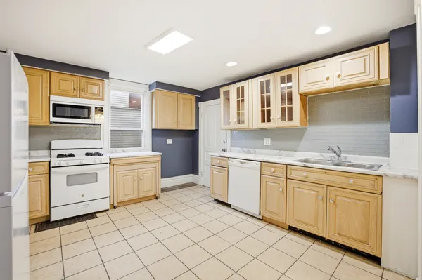 a kitchen with a refrigerator and white cabinets