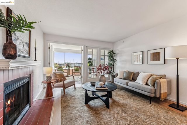 a living room with furniture a fireplace and a potted plant