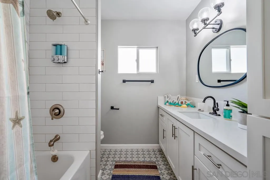 808 Leonard Avenue Oceanside, CA 92054 - Photo 14 of 25 a bathroom with a sink a mirror a vanity and a bathtub