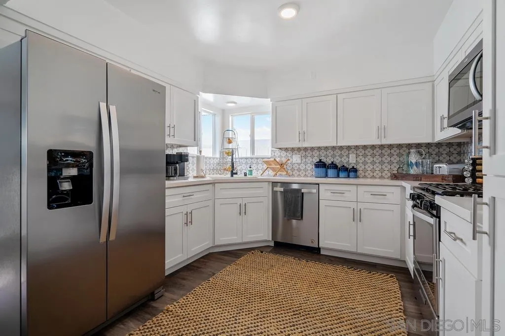 808 Leonard Avenue Oceanside, CA 92054 - Photo 9 of 25 a kitchen with white cabinets stainless steel appliances and a window