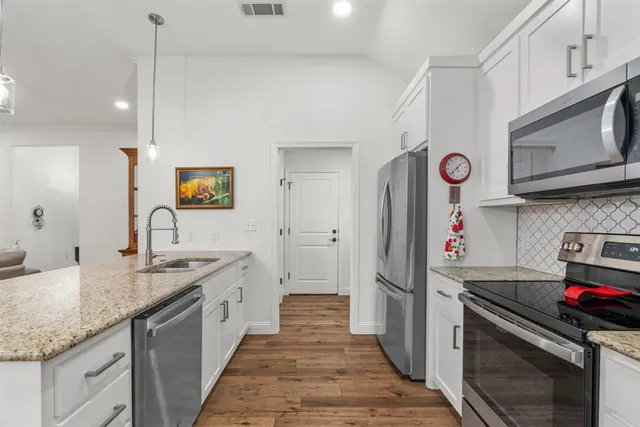 a kitchen with stainless steel appliances granite countertop a sink stove and refrigerator