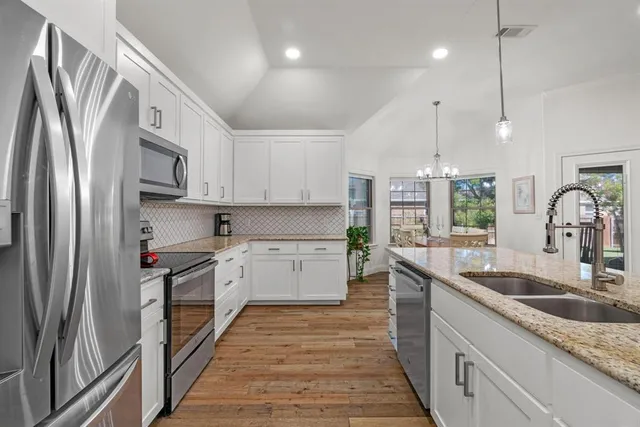 a kitchen with stainless steel appliances granite countertop a sink stove and refrigerator
