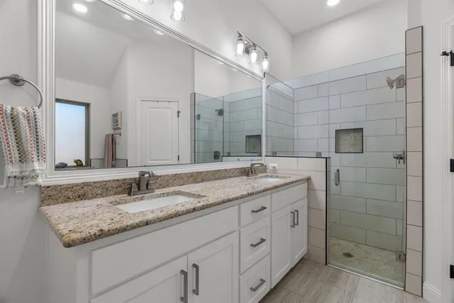 a bathroom with a granite countertop sink double and mirror