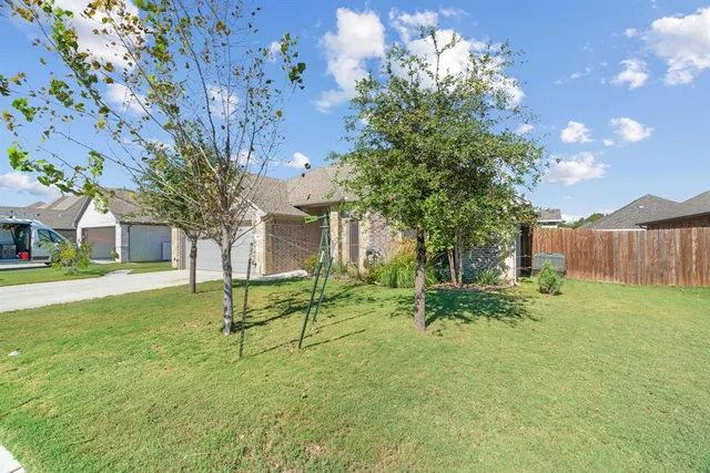 a view of backyard with table and chairs and wooden fence