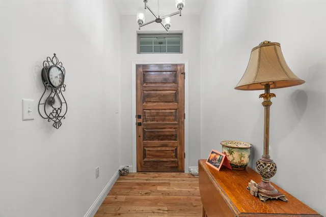 a view of a hallway with entryway wooden floor and front door