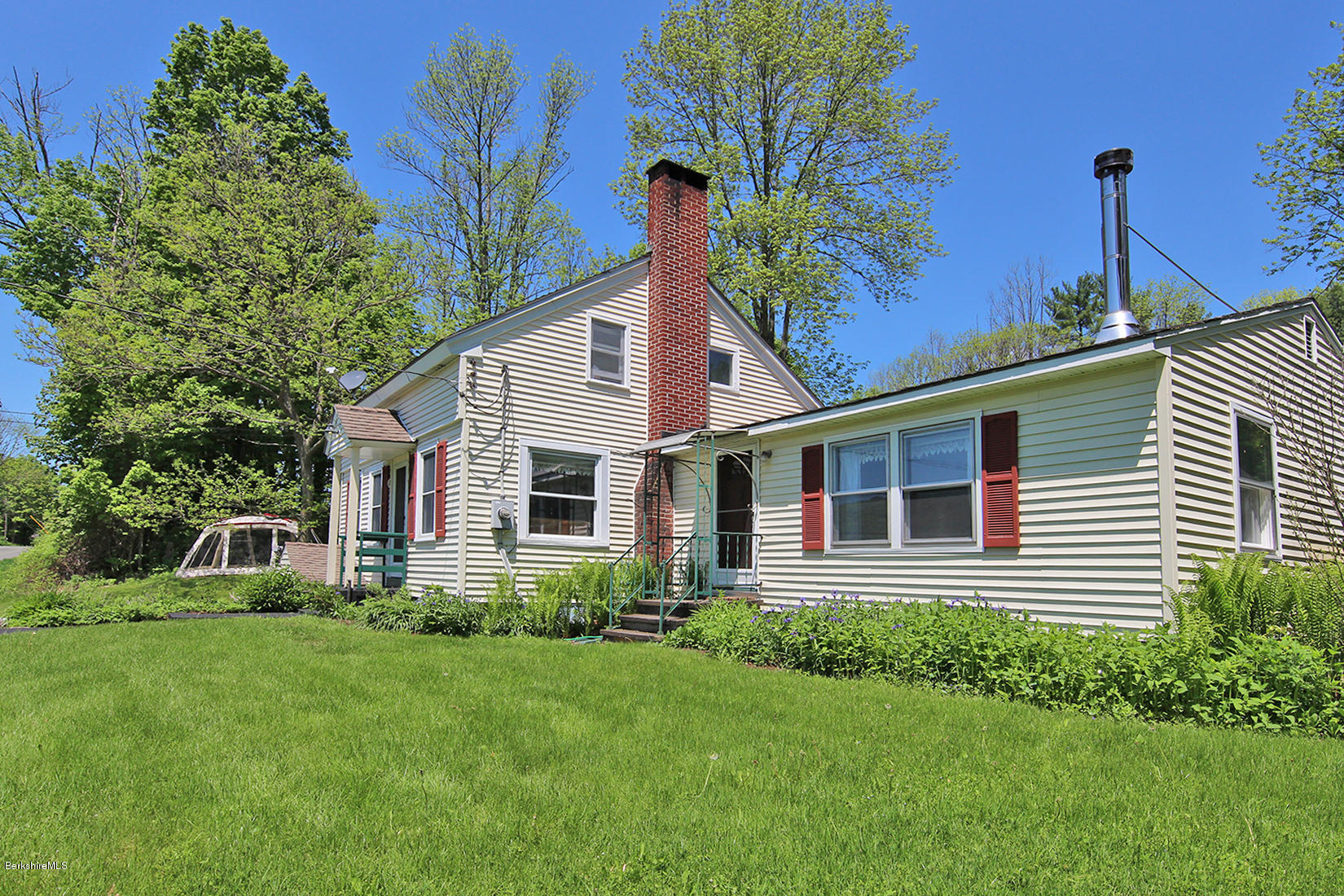 49 Main Road Tyringham, MA 01238 - Photo 3 of 32 a front view of a house with a yard and potted plants