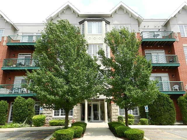 620 McHenry Road, Unit 303 Wheeling, IL 60090 - Photo 1 of 18 a front view of a building with trees