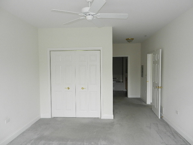 620 McHenry Road, Unit 303 Wheeling, IL 60090 - Photo 15 of 18 an empty room with closet and a ceiling fan
