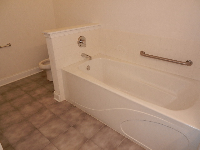 620 McHenry Road, Unit 303 Wheeling, IL 60090 - Photo 17 of 18 a bathroom with a bathtub and a toilet