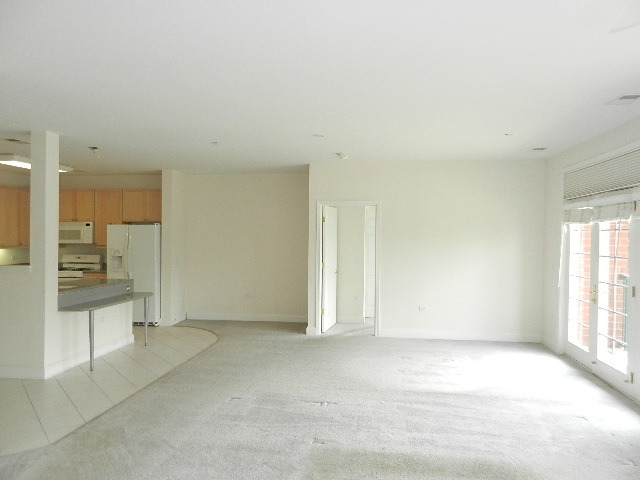 620 McHenry Road, Unit 303 Wheeling, IL 60090 - Photo 8 of 18 an empty room with a kitchen