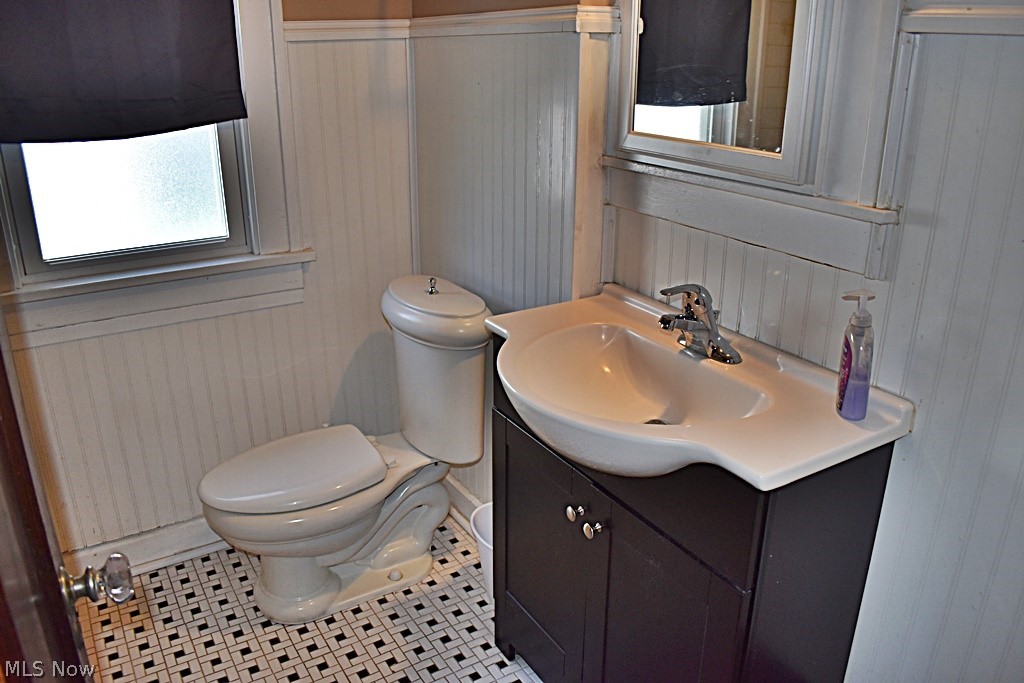 7715 Ackley Road Parma, OH 44129 - Photo 14 of 27 Bathroom featuring tile flooring, a healthy amount of sunlight, oversized vanity, and toilet