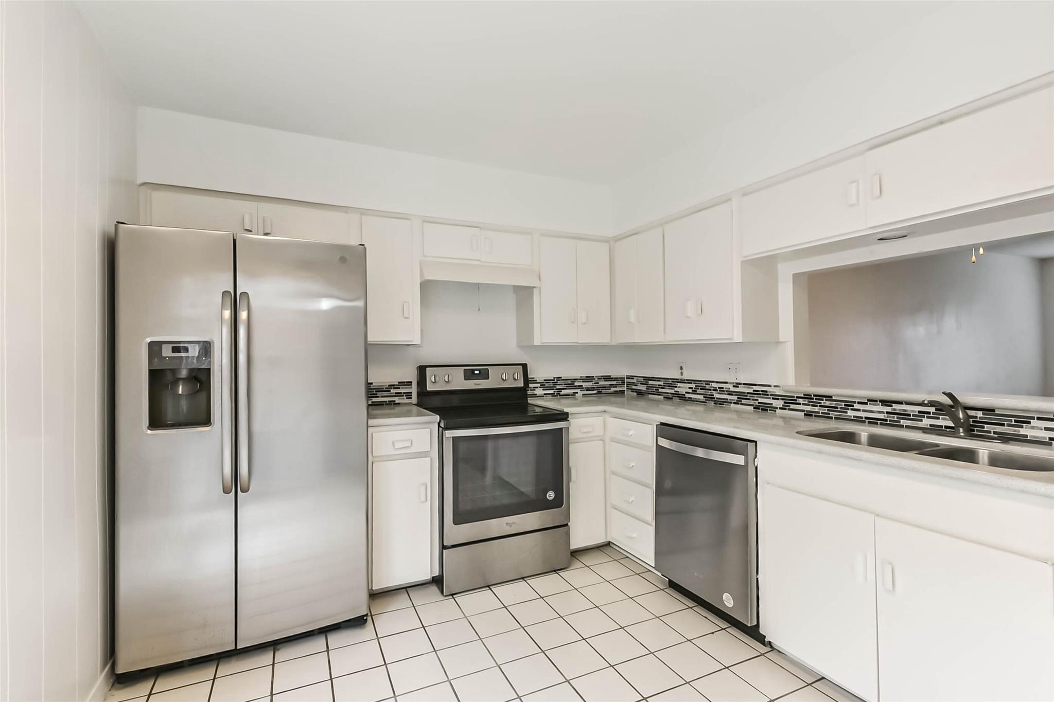 815 South Ripple Creek Drive, Unit 4 Houston, TX 77057 - Photo 4 of 12 a kitchen with stainless steel appliances granite countertop a stove a refrigerator and a sink