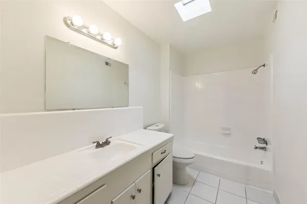 a bathroom with a granite countertop sink a toilet and shower