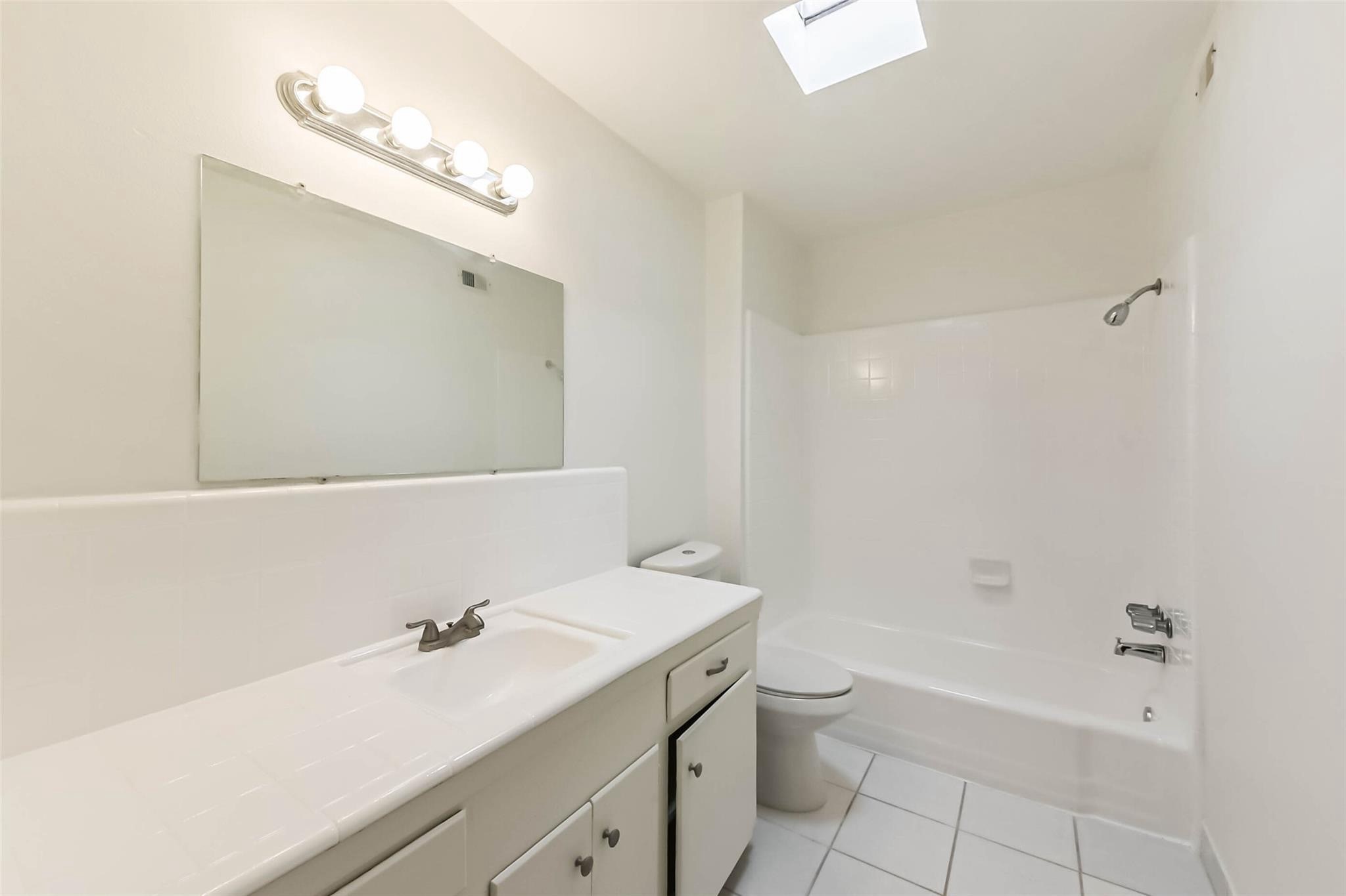 815 South Ripple Creek Drive, Unit 4 Houston, TX 77057 - Photo 7 of 12 a bathroom with a granite countertop sink a toilet and shower