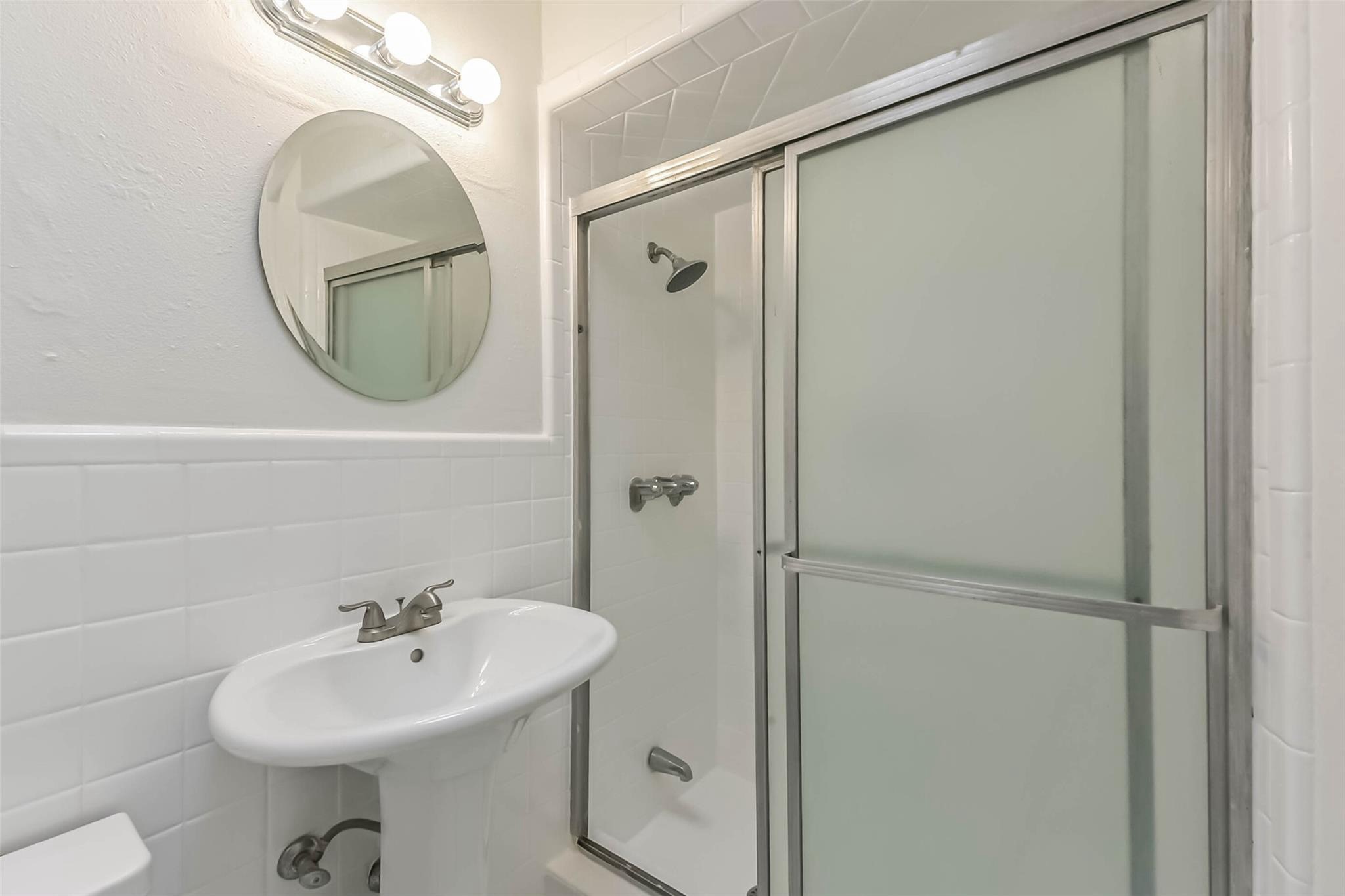 815 South Ripple Creek Drive, Unit 4 Houston, TX 77057 - Photo 9 of 12 a bathroom with a sink a mirror a toilet and a shower