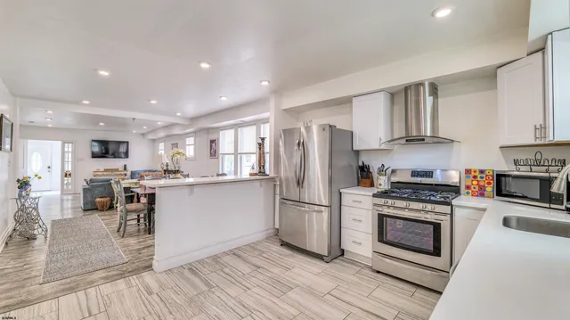 a kitchen with stainless steel appliances a refrigerator a stove top oven and sink