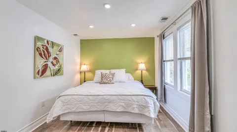 a bedroom with a bed and painting on the wall