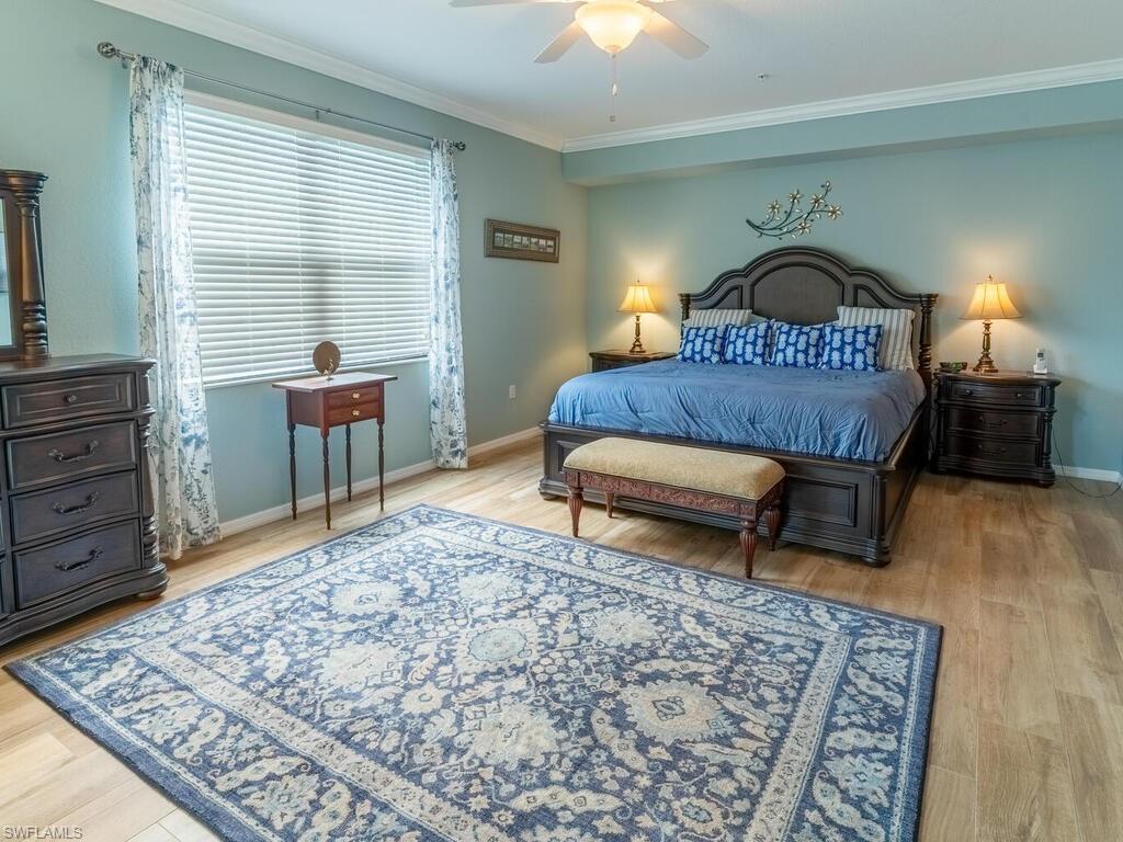 9115 Napoli Court, Unit 101 Naples, FL 34113 - Photo 12 of 49 a bedroom with a bed a dresser and chair