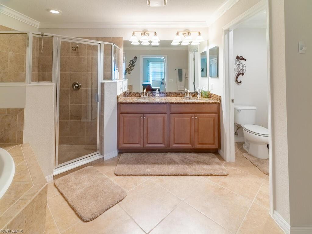 9115 Napoli Court, Unit 101 Naples, FL 34113 - Photo 14 of 49 a bathroom with a sink a toilet and shower
