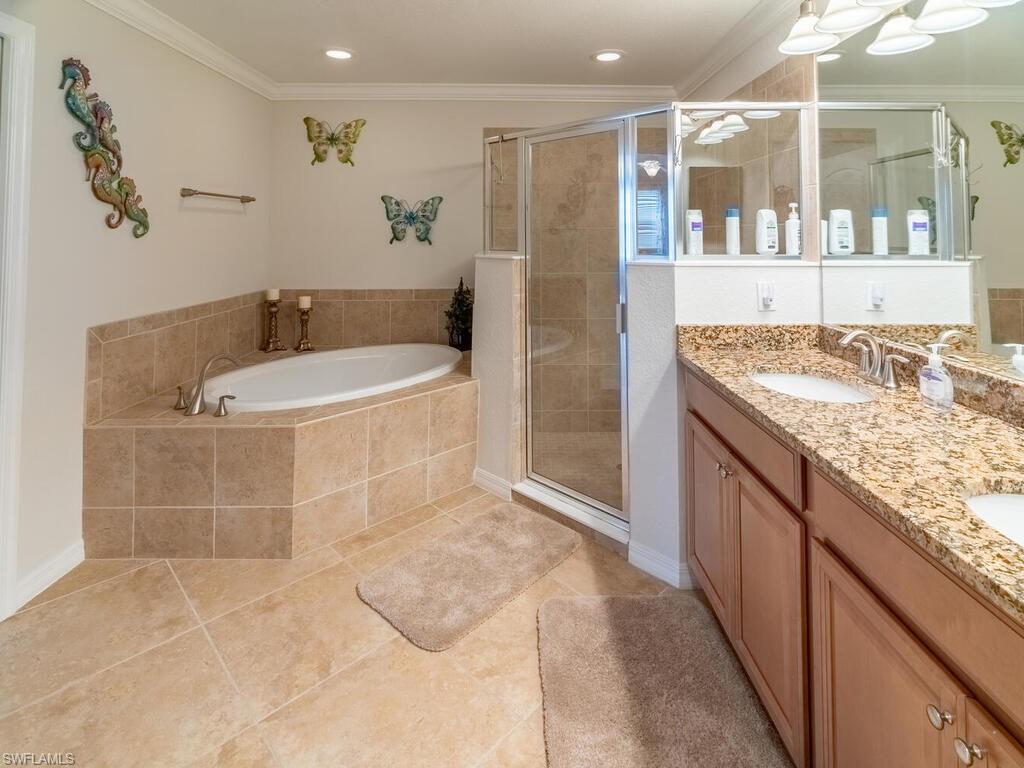9115 Napoli Court, Unit 101 Naples, FL 34113 - Photo 16 of 49 a bathroom with a granite countertop sink a mirror and shower