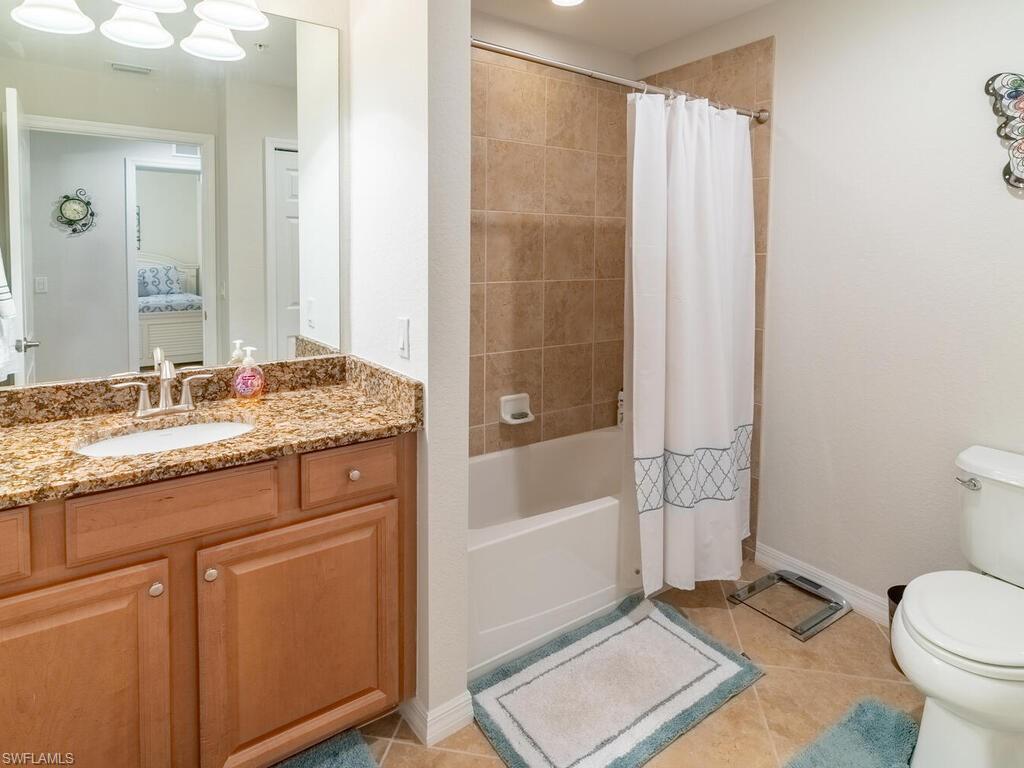 9115 Napoli Court, Unit 101 Naples, FL 34113 - Photo 20 of 49 a bathroom with a granite countertop sink a toilet and shower