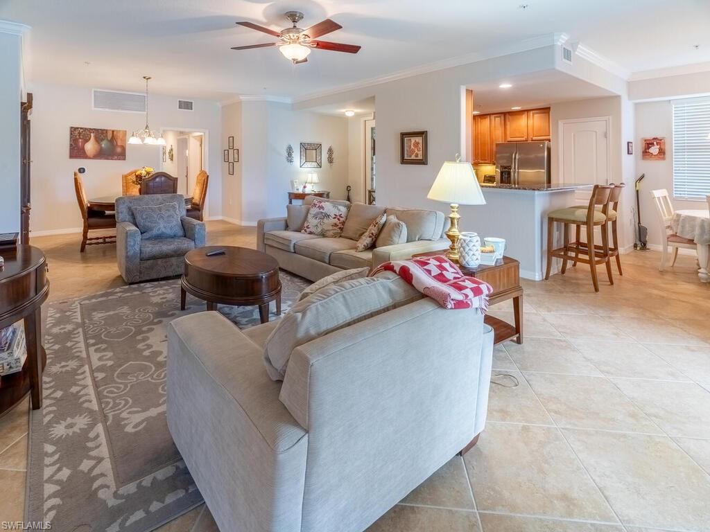 9115 Napoli Court, Unit 101 Naples, FL 34113 - Photo 4 of 49 a living room with furniture and a flat screen tv