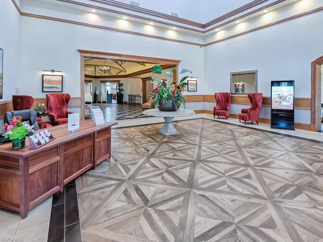 a living room with patio furniture and a floor to ceiling window next to a yard