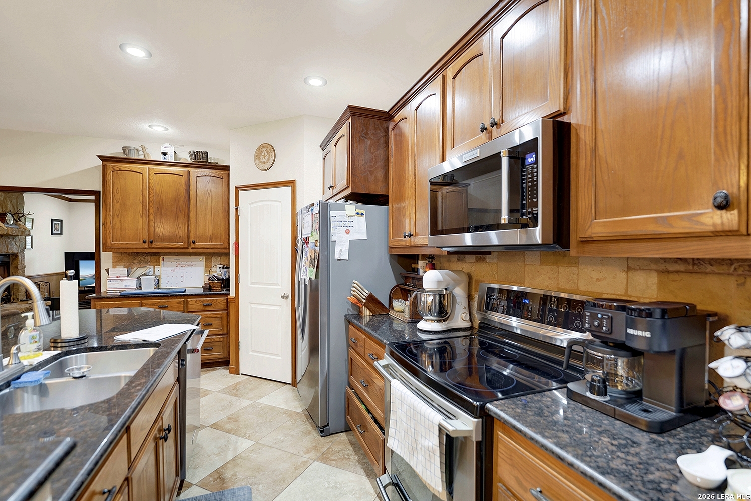 3283 Hartfield Road La Vernia, TX 78121 - Photo 11 of 40 a kitchen with stainless steel appliances a stove a sink and a microwave
