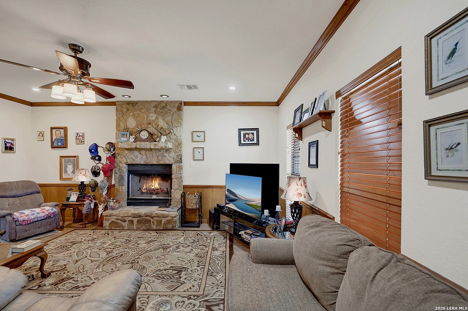 3283 Hartfield Road La Vernia, TX 78121 - Photo 16 of 40 a living room with furniture a fireplace and a flat screen tv