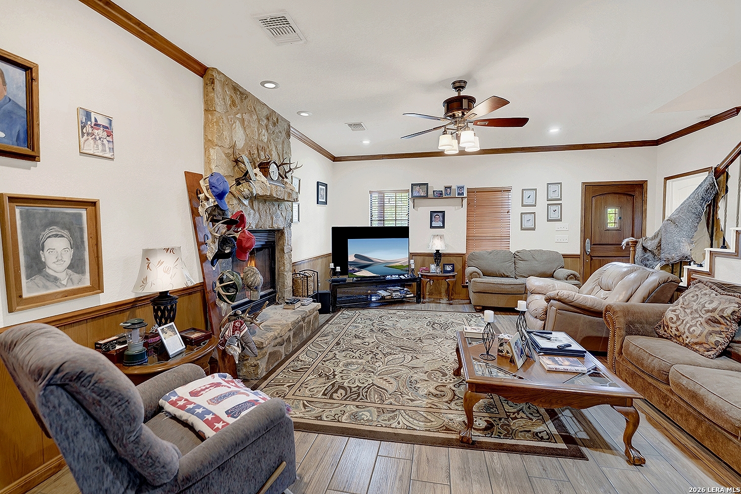 3283 Hartfield Road La Vernia, TX 78121 - Photo 17 of 40 a living room with furniture a fireplace and a flat screen tv
