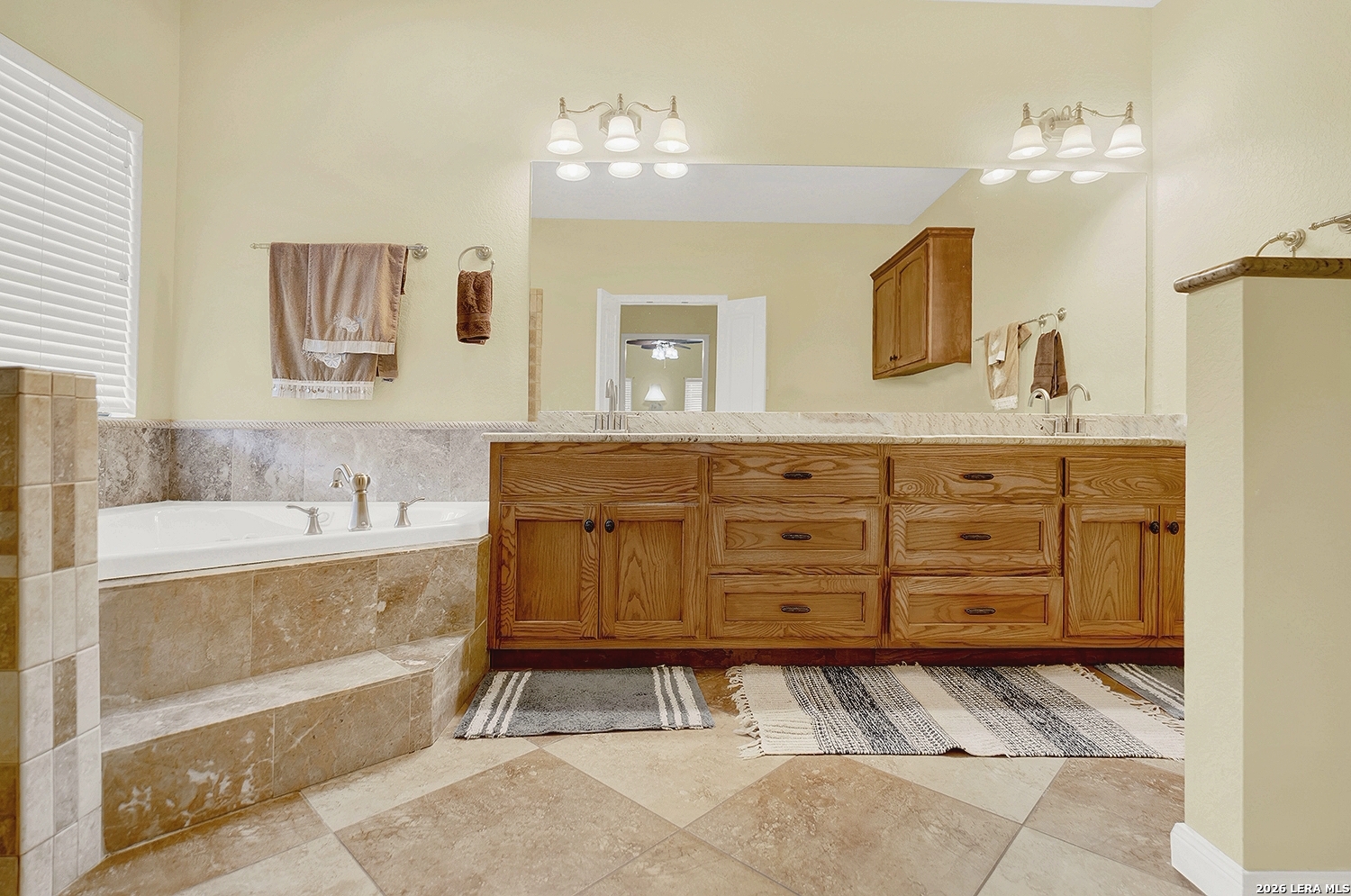 3283 Hartfield Road La Vernia, TX 78121 - Photo 24 of 40 a bathroom with a granite countertop sink a mirror and bathtub