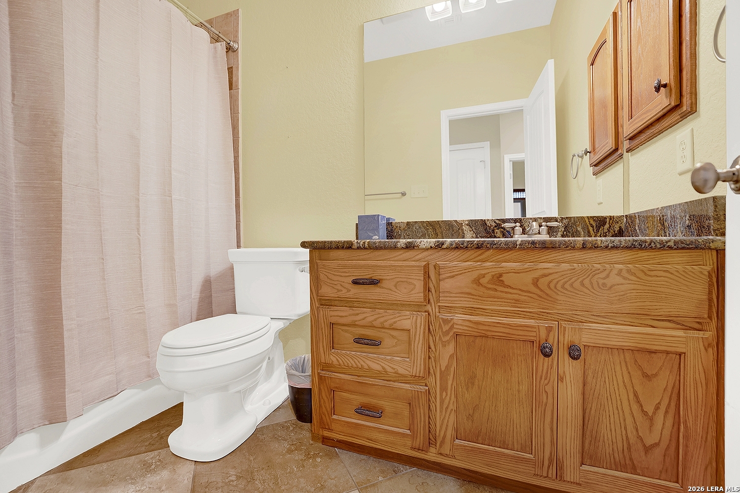 3283 Hartfield Road La Vernia, TX 78121 - Photo 29 of 40 a bathroom with a granite countertop toilet sink and mirror